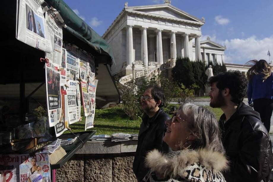Habitantes de Atenas leen las portadas de periódicos que reflejan la victoria de Syriza en las últimas elecciones. / EFE