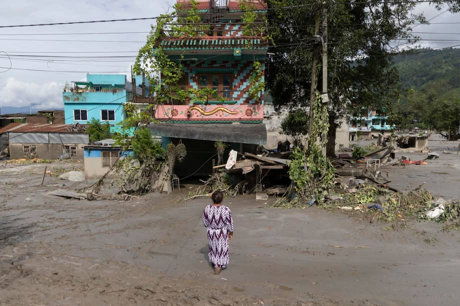 Un sobreviviente de las inundaciones regresa a su casa tras una crecida repentina en la aldea de Devighat, en el distrito de Nuwakot, Nepal, el 27 de agosto de 2026.