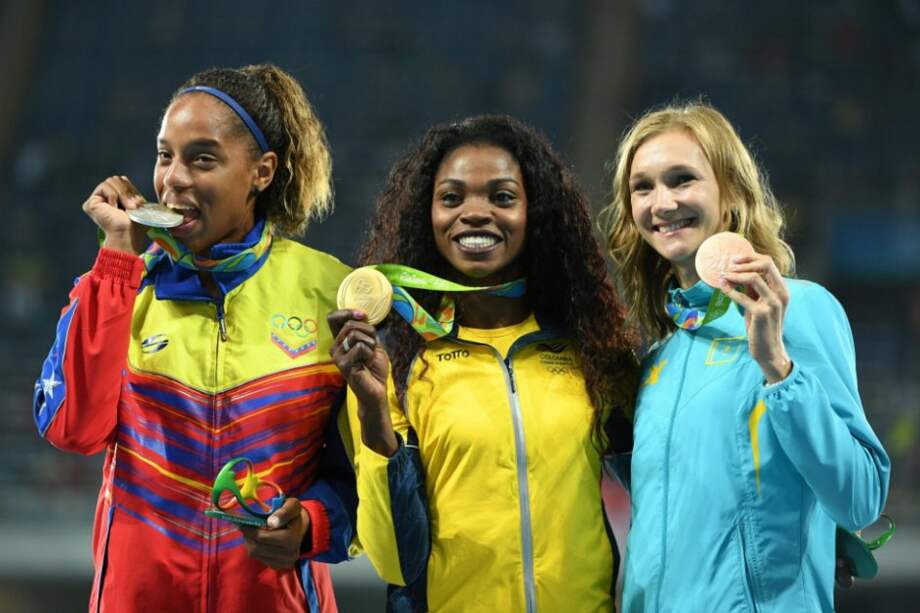 La atleta colombiana Caterine Ibargüen (c) con la medalla de oro del salto triple, junto a la venezolana Yulimar Rojas (i), que ganó plata, y la kazaja Olga Rypakova (d), dueña del bronce. / AFP