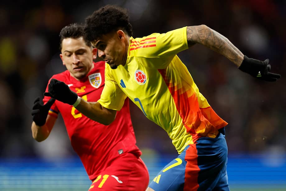 El delantero colombiano #07 Luis Díaz (R) corre con el balón junto al mediocampista rumano #21 Olimpiu Morutan durante el partido de fútbol amistoso internacional entre Rumania y Colombia en el estadio Metropolitano de Madrid el 26 de marzo de 2024.