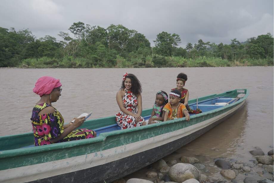 La docente Martha Cecilia Cortés le lee cuentos a los niños a orillas del río Caquetá en Puerto Limón, Mocoa.