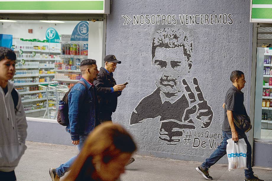 En las calles de Caracas, Venezuela, varias personas pasan junto a un mural de Maduro en el que se lee: “Nosotros venceremos”.