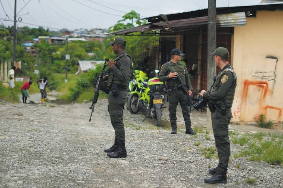 Foto de archivo que muestra a agentes de Policía en una guardia junto a un edificio cubierto de grafitis relacionados con pandillas en Buenaventura. (AP Photo/Fernando Vergara)
