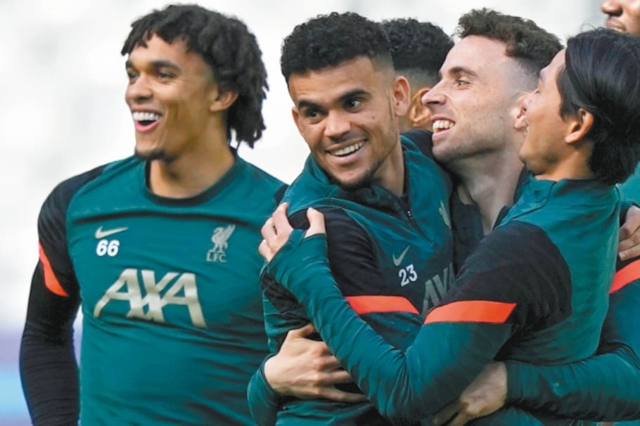 Liverpool's Diogo Jota, center, embraces teammates Luis Diaz and Takumi Minamino, right, during a training session at the State de France in Saint Denis near Paris, Friday, May 27, 2022. Liverpool and Real Madrid are making their final preparations before facing each other in the Champions League final soccer match on Saturday. (AP Photo/Frank Augstein)