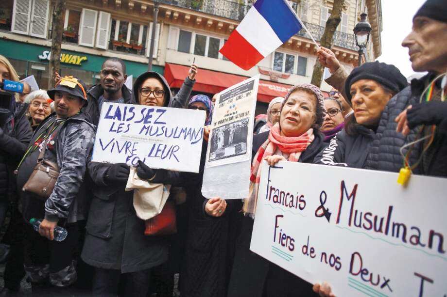 Un grupo de ciudadanos durante una manifestación contra la islamofobia, en París. El cartel de la izquierda dice: “Dejemos que los musulmanes vivan su fe”. / AFP
