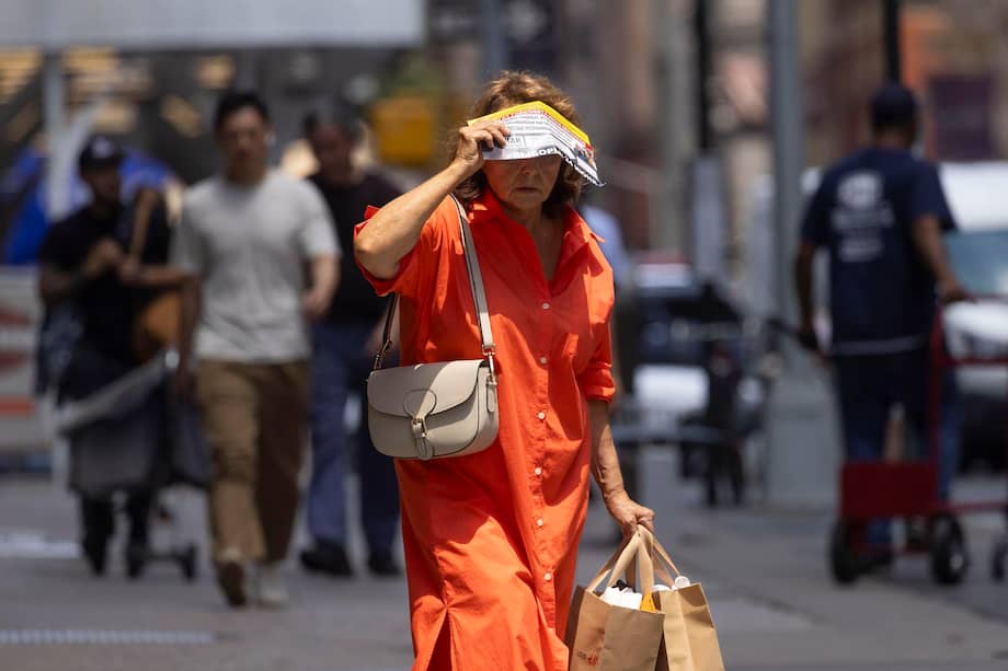 Una persona se cubre del sol mientras camina por Broadway, en la ciudad de Nueva York (Estados Unidos).