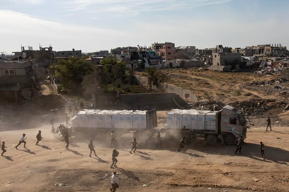 Palestinos desplazados persiguen un camión de ayuda humanitaria en medio de un alto el fuego entre Israel y Hamás en Rafah, sur de la Franja de Gaza