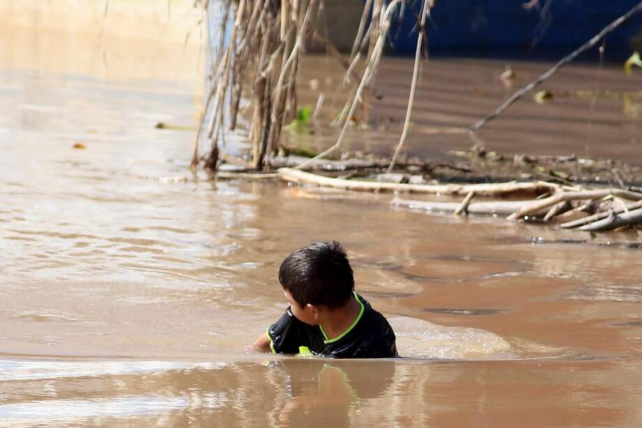 Un niño que juega en aguas estancadas dejadas por las inundaciones causadas por las tormentas tropicales Eta y Iota.