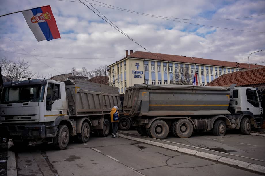 Un peatón pasa frente a una nueva barricada instalada en la ciudad dividida de Mitrovica el 28 de diciembre de 2022.