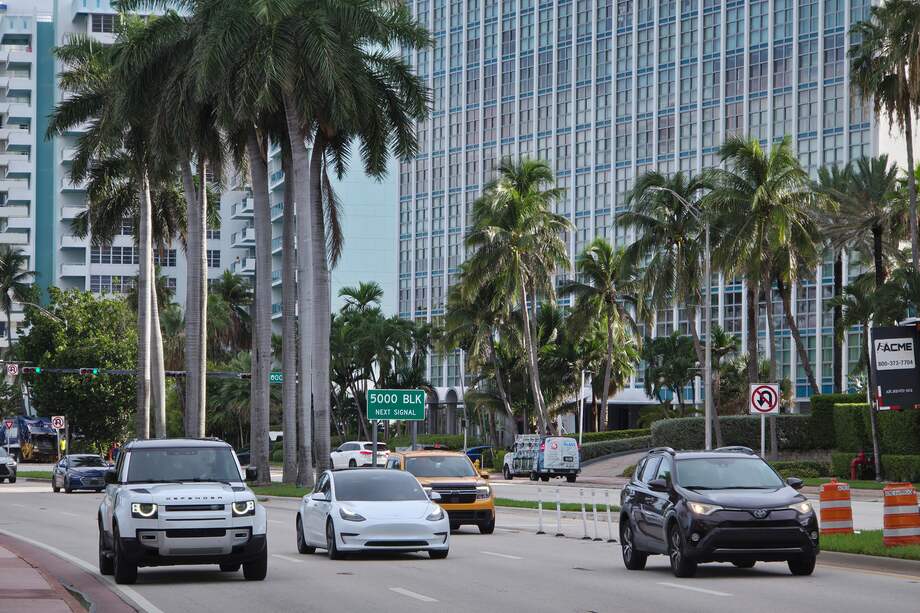 Vehículos transitan frente a los edificios en la avenida Collins de Miami (Florida).