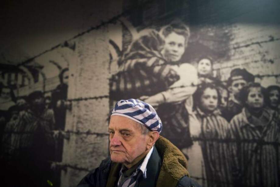 Igor Malitski, sobreviviente ucraniano del Holocausto pasa junto a unapintura en una de las barracs del campo de concentración de Auschwitz en Oswiecim. Sobrevivientes llegaron a la recordación del 70 aniversario de la liberación de este campo. / AFP