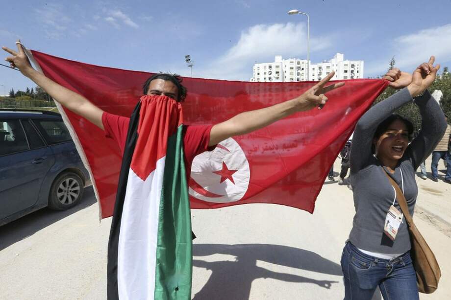 Asistentes al XX Fórum Social Mundial muestran una bandera palestina y otra de Túnez durante la celebración del foro en Túnez