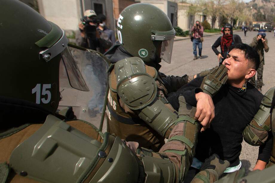 Un manifestante es detenido por las autoridades en el marco de la conmemoración del aniversario 45 del golpe de Estado del 11 de septiembre de 1973 en Chile. / AFP