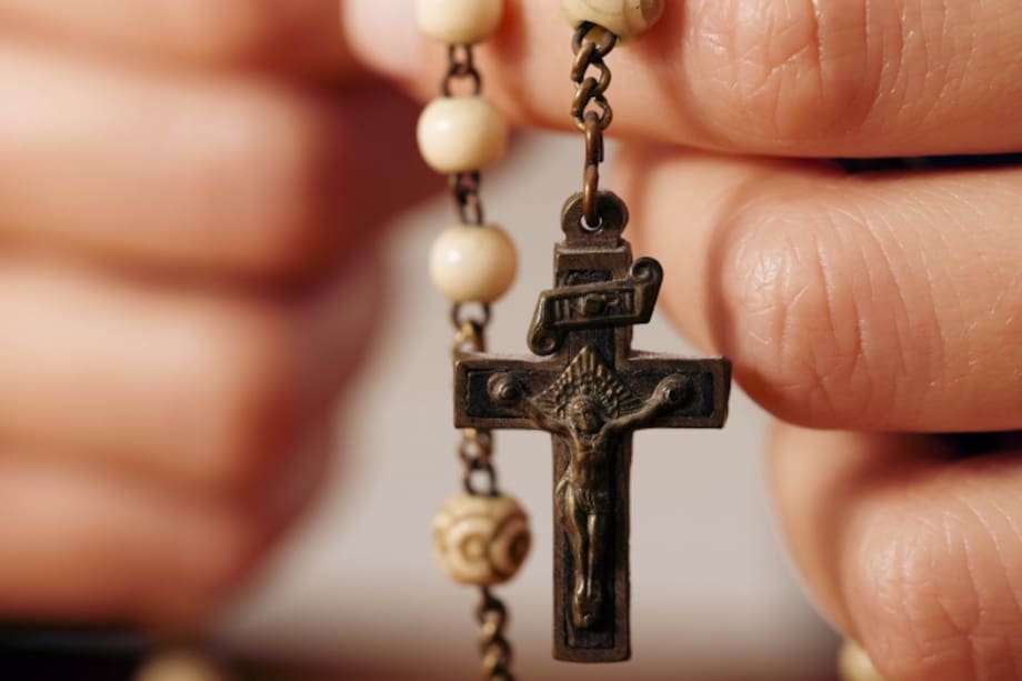 Mujer cargando en sus manos un rosario
