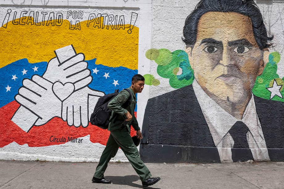 Una persona camina frente a un mural con la imagen del empresario colombiano Alex Saab en una calle en Caracas (Venezuela).
