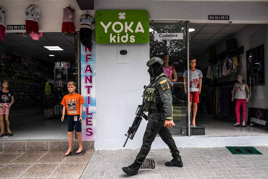 A member of Colombia's national police patrols the streets of Savarena, Arauca, Colombia, near the Venezuelan border on January 23, 2022. - Five people were killed in two days in a region in northeastern Colombia bordering Venezuela, the scene of a bloody clash between dissidents from the former FARC guerrilla and ELN rebels, local police told AFP. (Photo by Juan BARRETO / AFP)