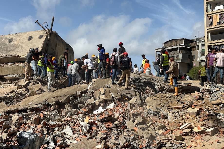 Personas caminan sobre los escombros de edificios derrumbados en el sector San Bernardino, en Caracas (Venezuela).