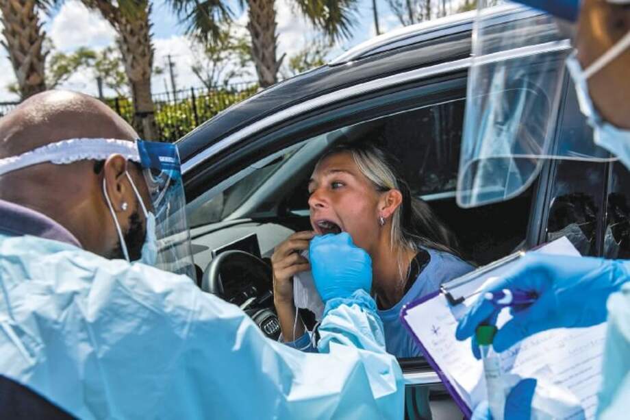 Un médico toma muestras de una ciudadana en un laboratorio de pruebas de coronavirus cerca a Miami. / AFP