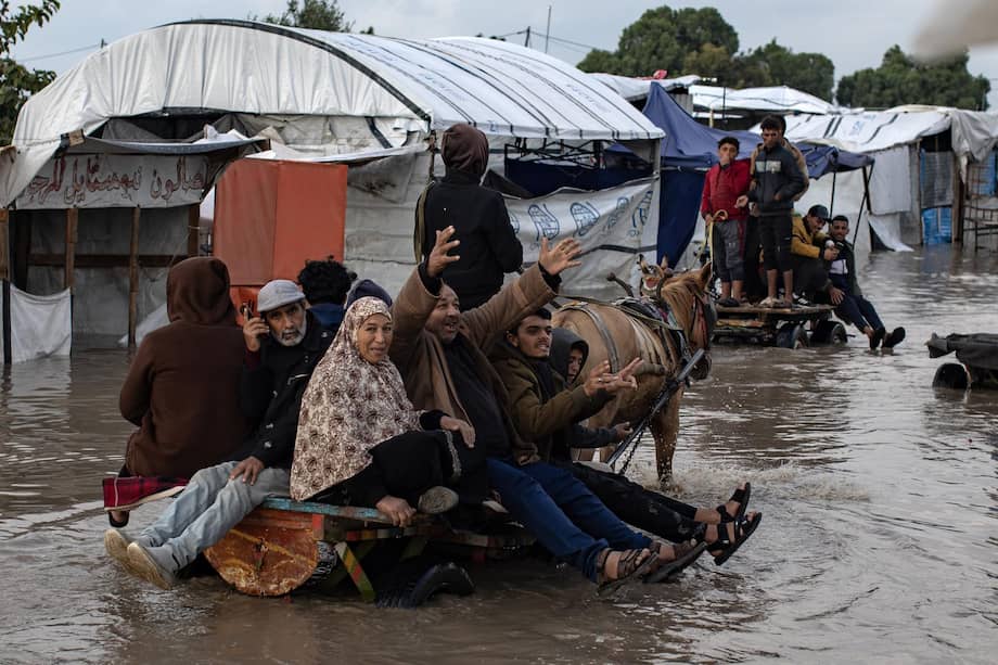 Palestinos desplazados avanzan en carros tirados por animales por una calle inundada tras fuertes lluvias en Jan Yunis, en el sur de Gaza, el 11 de diciembre de 2025.