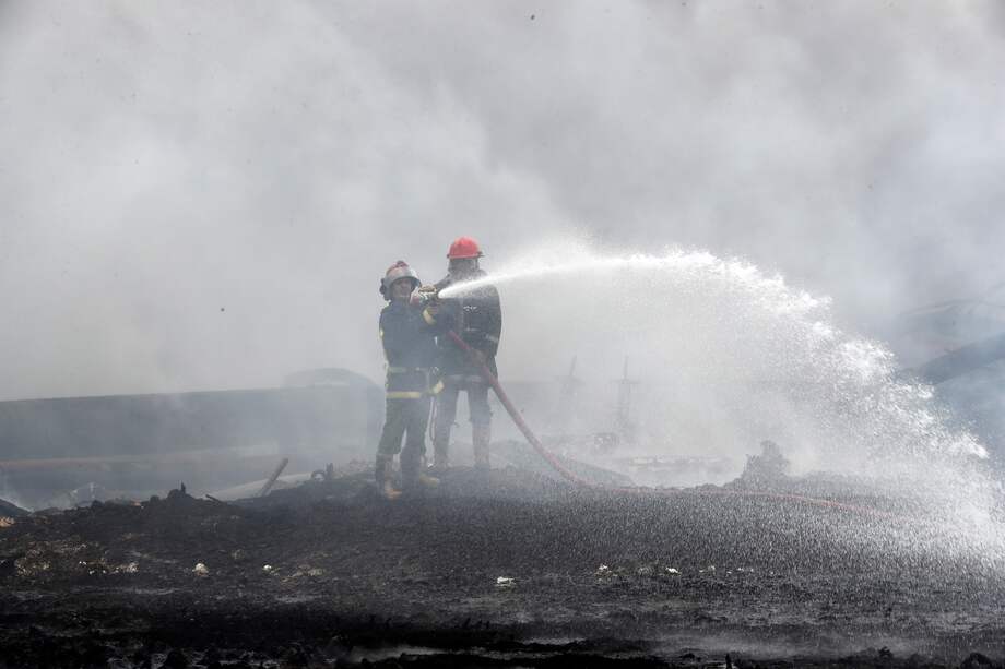 Unos bomberos trabajan en el lugar de la explosión en la base de contenedores de la zona industrial de Matanzas, Cuba.