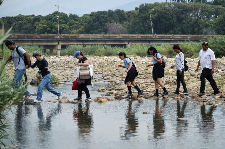La gente ha tenido que cruzar por trochas para ir hacia sus destinos. / AFP