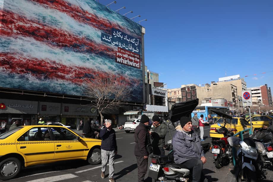 Iraníes caminan cerca de un enorme cartel anti-EE.UU. colgado en la plaza Enqelab en Teherán.