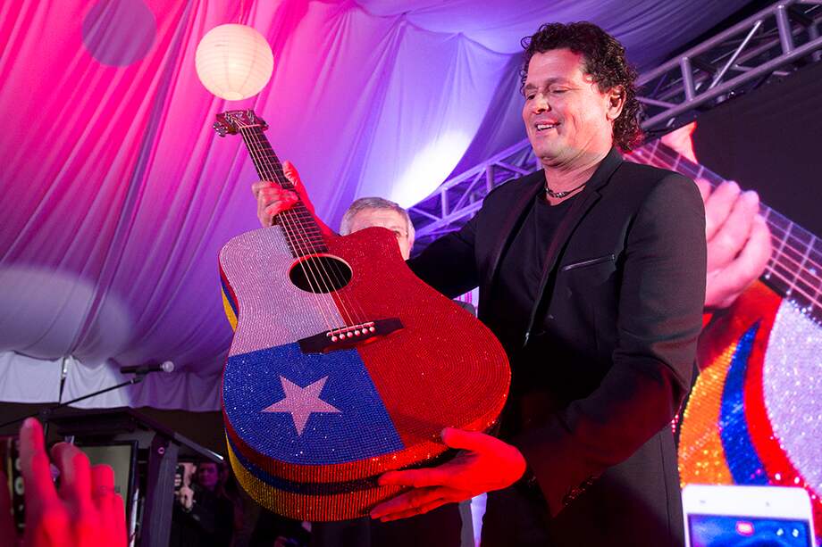 Carlos Vives regaló a la causa chilena una guitarra acústica decorada especialmente con 100.000 cristales de la joyería Swarovski. / AFP