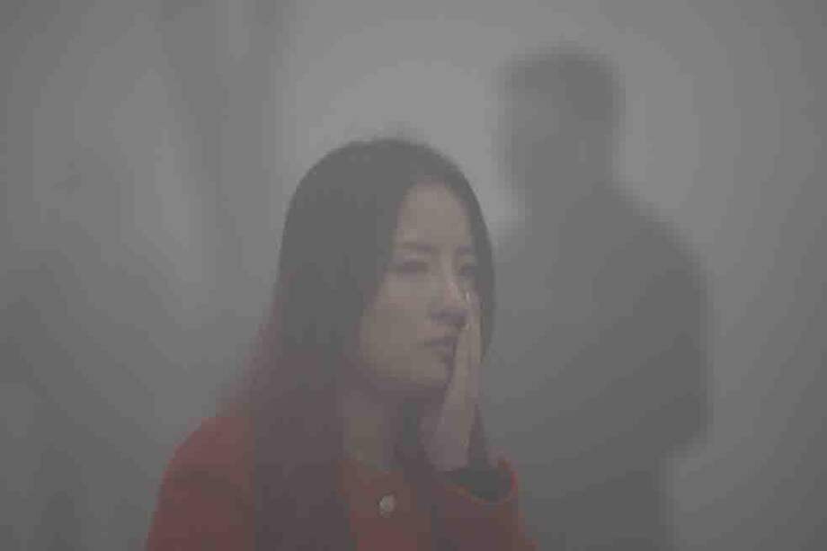 Esta mujer caminaba ayer por una calle en Harbin (China). / AFP