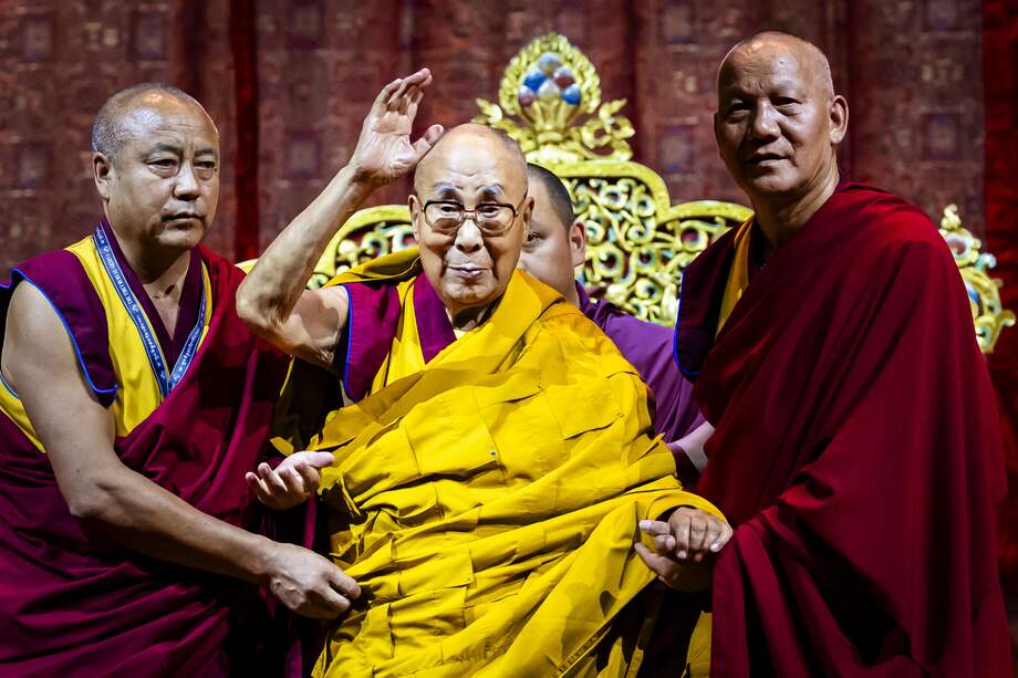 El líder espiritual del budismo tibetano, el Dalai Lama, Tenzin Gyatso (centro), es arropado por monjes tibetanos mientras asiste a una charla pública en Suiza.