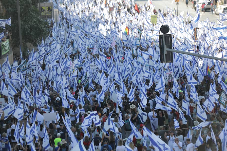 Miles de manifestantes antigubernamentales sostienen banderas israelíes durante una marcha de protesta que entra en Jerusalén para manifestarse contra los planes de reforma judicial del gobierno.