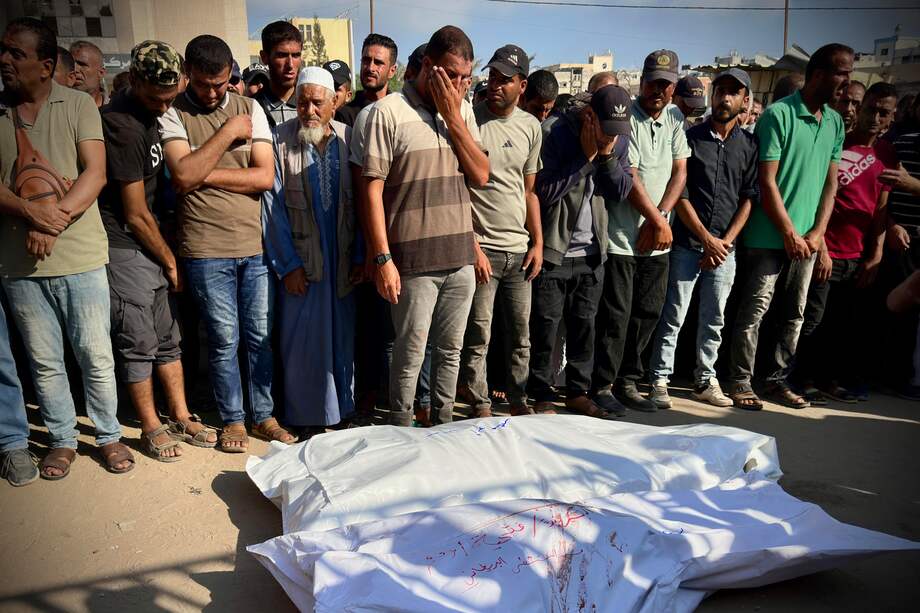 Personas rezan junto a los cadáveres tras la llegada de los cuerpos al Hospital Naser, en la localidad de Jan Yunis.