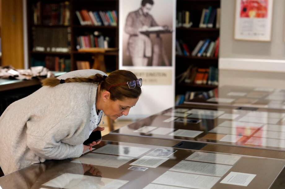 En esta foto de archivo tomada el 6 de marzo de 2019, una mujer revisa uno de los manuscritos de Albert Einstein expuestos en la Universidad Hebrea de Jerusalén Givat Ram.
