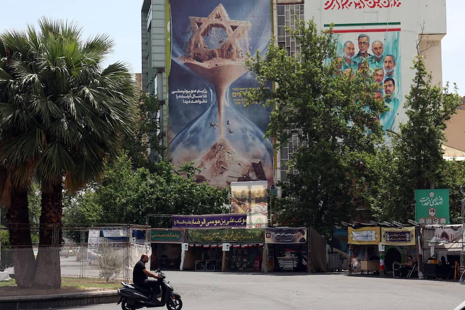 Los iraníes pasan frente a una valla publicitaria antiisraelí ubicada en la ciudad de Teherán.