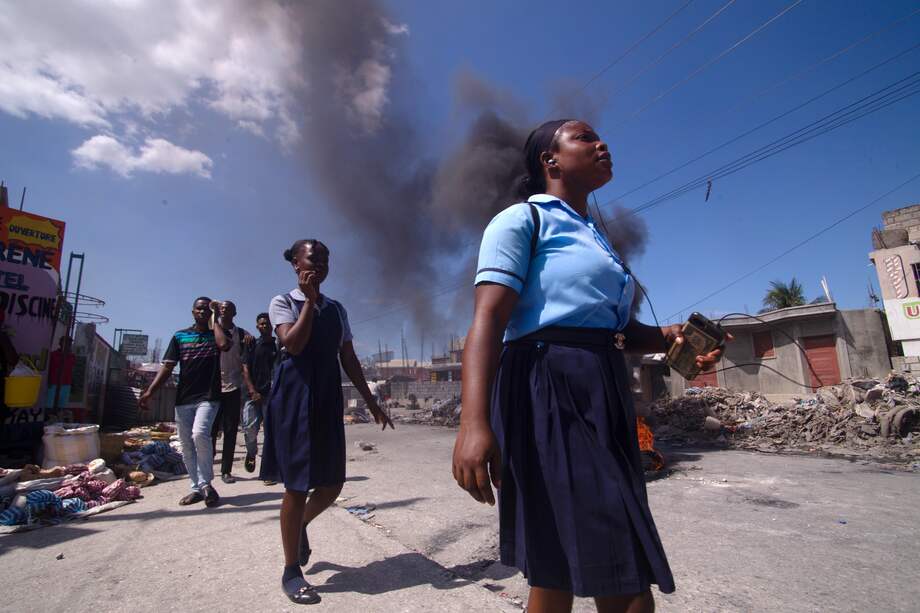 Personas caminan cerca de una barricada durante una nueva jornada de movilizaciones contra la inseguridad en la zona de Tabarre en Puerto Príncipe (Haití).