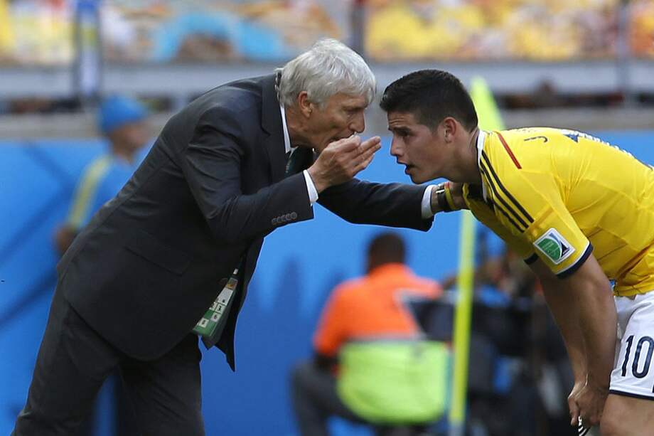 José Pékerman le da instrucciones al volante James Rodríguez durante el juego contra Grecia. / AFP