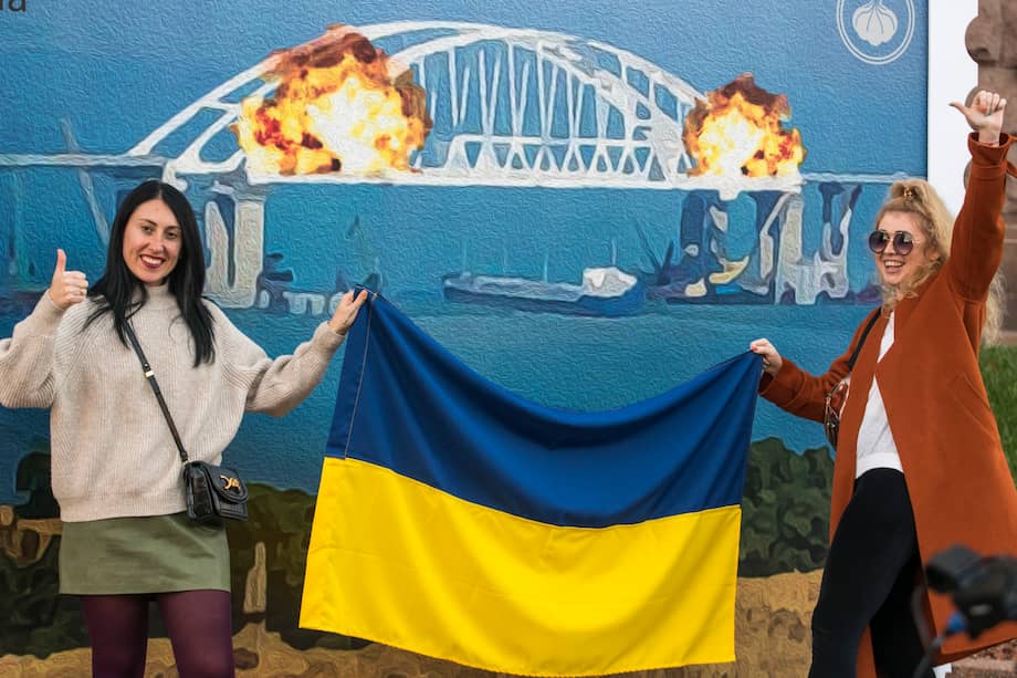 Ucranianas se toman selfies y posan para fotos frente a la imagen de unas explosiones sobre el puente del estrecho de Kerch. La obra se llama "Algodón sobre el puente de Crimea" y se exhibe en el centro de Kiev, Ucrania.