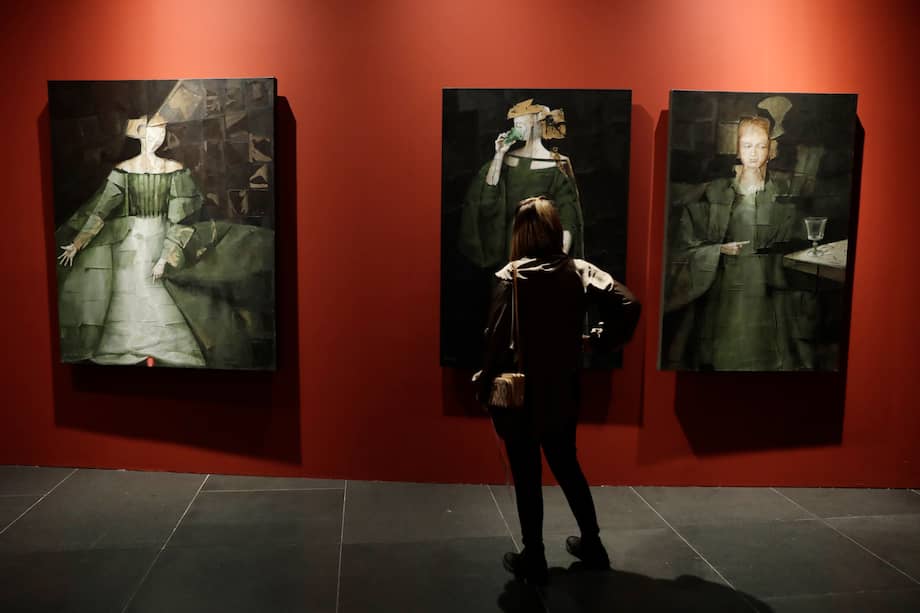 Una persona observa obras del pintor colombiano David Manzur este miércoles, en la Feria Internacional de Arte de Bogotá, (ArtBo) en Bogotá.