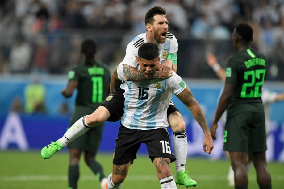 Los argentinos Marcos Rojo y Lionel Messi celebran el tanto que le dio la victoria a la albiceleste frente a Nigeria. / AFP