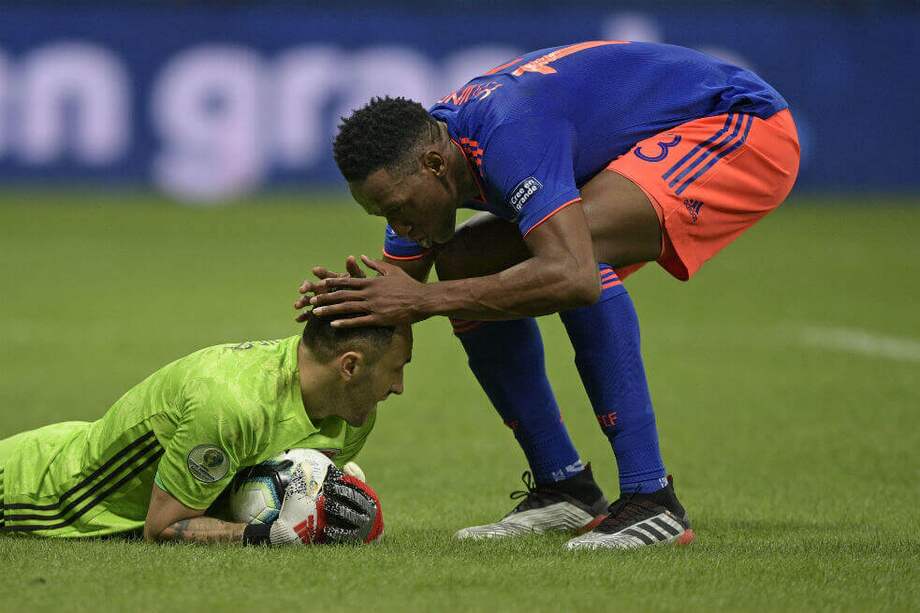 Mina (izqu.) luego de una atajada de David Ospina en el partido ante Argentina. / AFP
