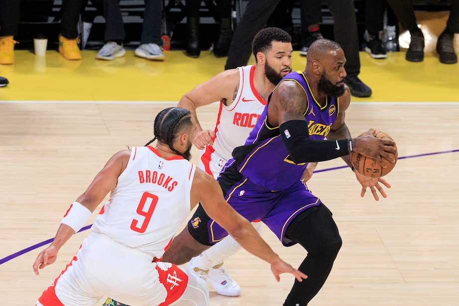 LeBron James, jugador de los Ángeles Lakers, disputa el balón con Fred VanVleet y Dillon Brooks, jugadores de los Houston Rockets.