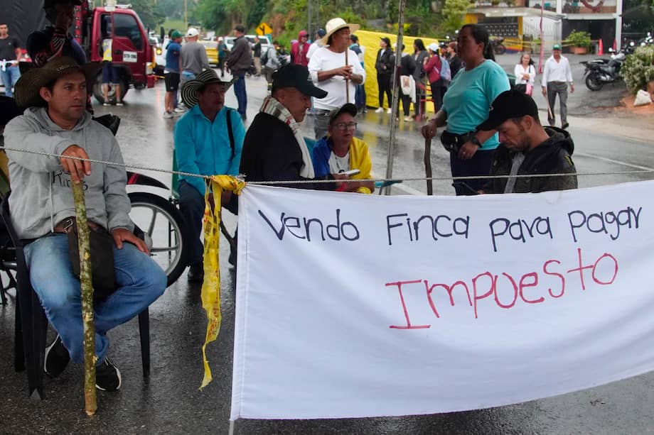 Personas participan en una manifestación para rechazar el incremento de los avalúos catastrales de sus propiedades, este lunes en la carretera que conduce al Aeropuerto Internacional Palonegro, en Lebrija. EFE/ Marco Valencia