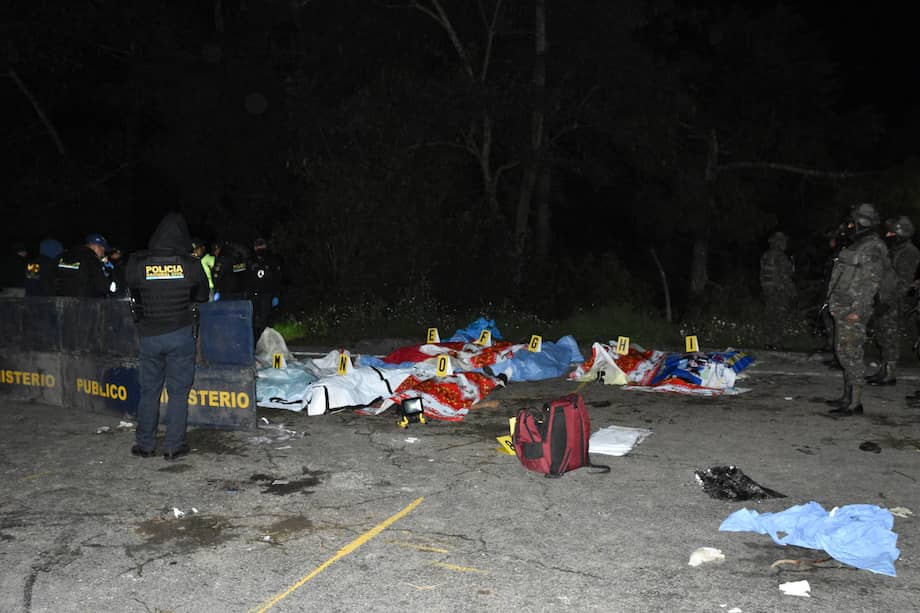 Miembros de las fuerzas de seguridad guatemaltecas vigilan junto a un grupo de víctimas después de que al menos quince personas murieran en la noche del viernes y otras diecinueve resultaran heridas durante un accidente de un bus de transporte público en el oeste de Guatemala, según confirmaron este sábado los cuerpos de socorro.