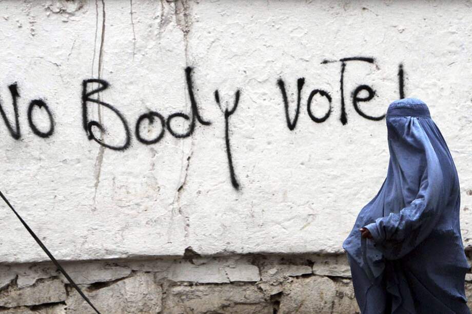 Una mujer con burka pasa junto a un grafiti en Herat, Afganistán. Las amenazas de fraude y la violencia han protagonizado los comicios presidenciales. / EFE