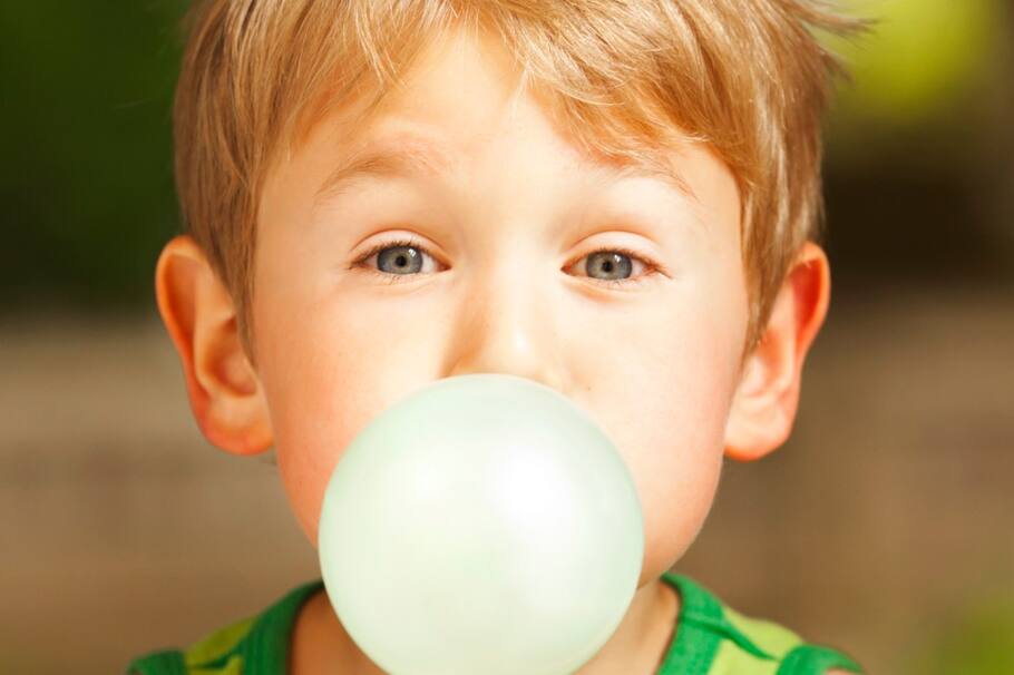 Niño con una goma de mascar.