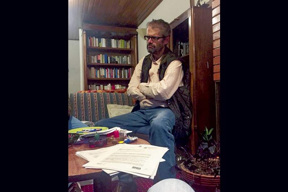 Fernando Arbeláez en la sala de su casa, con documentos con los que dice sustentar su versión.