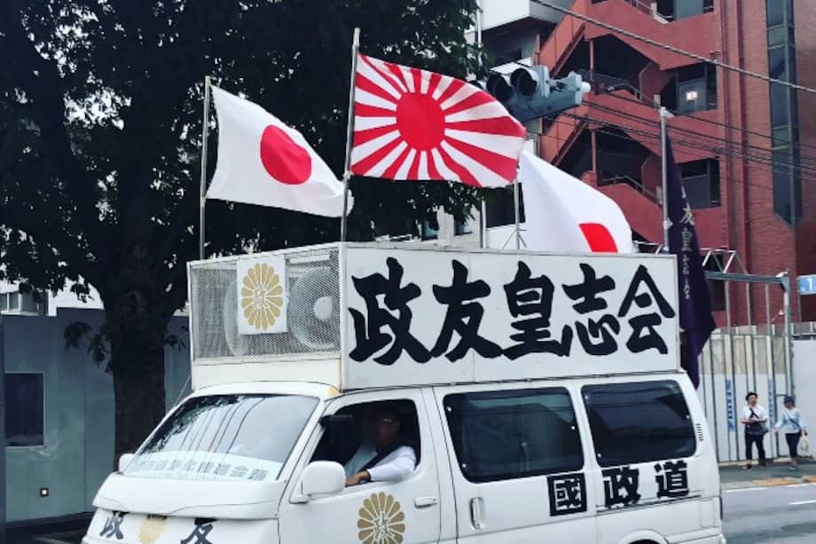 Vehículo de grupo nacionalista con la bandera nacional y la militar de los 16 rayos, en el barrio de Roppongi en Tokio. Por los parlantes suenan marchas militares y consignas generalmente anticomunistas.