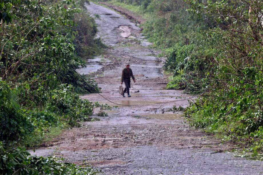 Una persona camina en una carretera este miércoles, en el poblado de Guama en Santiago de Cuba (Cuba), a donde Melisa llegó como un huracán categoría 2.