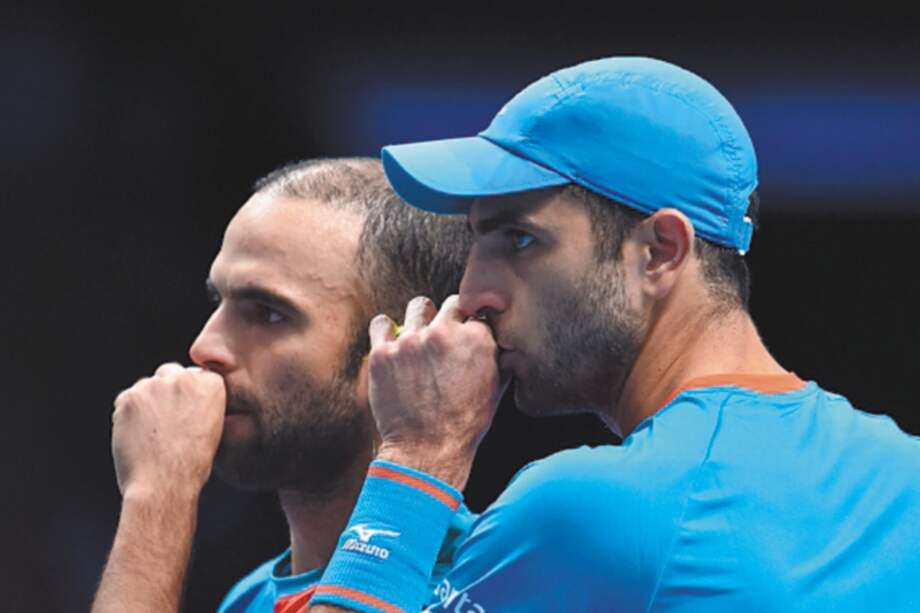 Colombia's Juan Sebastian Cabal (L) and Colombia's Robert Farah (R) speak between points against South Africa's Raven Klaasen and New Zealand's Michael Venus in their men's doubles round-robin match on day five of the ATP World Tour Finals tennis tournament at the O2 Arena in London on November 15, 2018. / AFP / Glyn KIRK