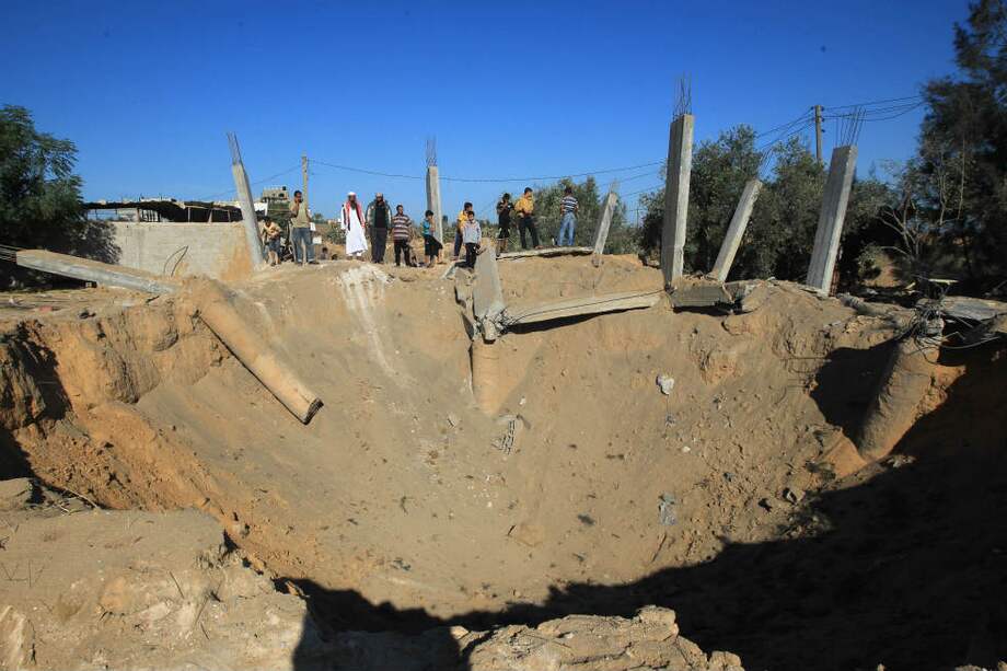 Palestinos inspeccionan un cráter que dejó el ataque israelí a Al-Bureij, centro de la Franja de Gaza, luego de que un grupo de militantes dispararan 11 rockets la semana pasada. / AFP