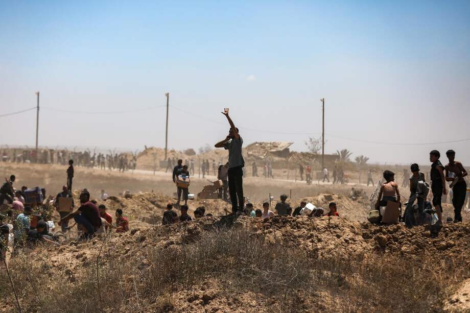 Foto de archivo: Palestinos transportan ayuda humanitaria de la Fundación Humanitaria de Gaza, respaldada por Estados Unidos, a través del Corredor Netzarim, en el centro de la Franja de Gaza, el 29 de mayo de 2025.